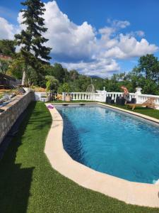 a swimming pool in a yard with a stone wall at Chambre d hote in Le Tignet