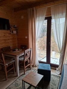 a living room with a table and a large window at Vikendica Neven 3 in Popovići +22 photos