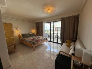 a bedroom with a bed and a couch and a window at Nest by Aerial Lanta in Ko Lanta