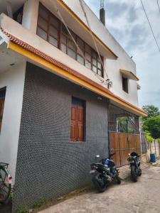 a house with two motorcycles parked outside of it at Yaazhi Boutique Homestay in Pondicherry
