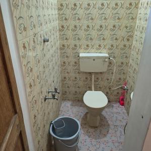 a bathroom with a toilet and a trash can at Yaazhi Boutique Homestay in Pondicherry