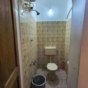 a bathroom with a toilet and a trash can at Yaazhi Boutique Homestay in Pondicherry