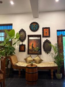 a living room with a couch and plates on the wall at Yaazhi Boutique Homestay in Pondicherry +64 photos