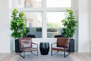 two chairs and a table in a room with plants at Quality Inn & Suites Lathrop in Lathrop