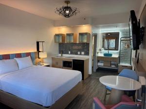 a bedroom with a bed and a kitchen and a bathroom at Rodeway Inn Encinitas North in Encinitas