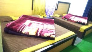 two beds in a room with purple blankets on them at Hotel Venkatesh in Badrinath