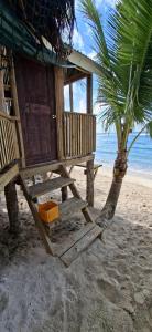 a hut on the beach with a palm tree at DO NOT USE this in Apia