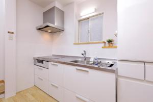 a white kitchen with a sink and a window at 桜ノ舎 in Nara +43 photos