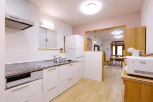 a kitchen with white cabinets and a sink at 桜ノ舎 in Nara