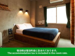 a room with a bed and a window at Untapped Hostel in Sapporo