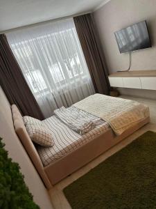a bedroom with a bed in front of a window at Квартира на Перемоги in Lutsk