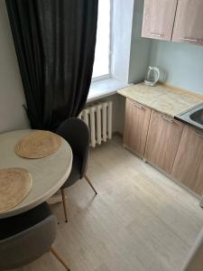 a kitchen with a table and two chairs and a window at Квартира на Перемоги in Lutsk