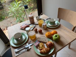 a wooden table with plates of food on it at Logis Hôtel Restaurant Les Norias in Cazilhac