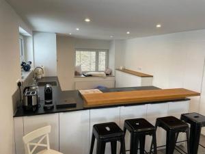 a kitchen with a counter top with four stools at Auszeit im Hegau Bodenseenahe Ferienwohnung in Engen