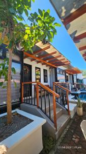 a house with a deck with a tree at Jolie Joes One Bedroom Unit in Tagudin
