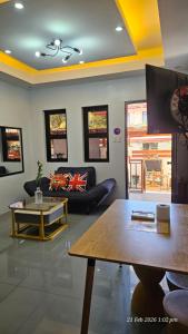 a living room with a couch and a table at Jolie Joes One Bedroom Unit in Tagudin