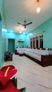 a large living room with couches and a ceiling fan at Aksha Homestay in Sakleshpur