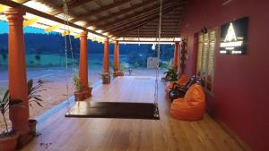 a porch with a swing in the middle of a room at Aksha Homestay in Sakleshpur