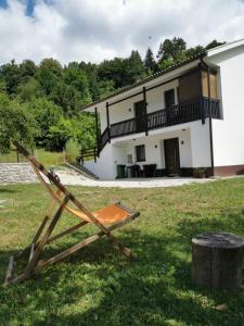 a chair in the grass in front of a house at Apartma Bella Nadiža in Kobarid
