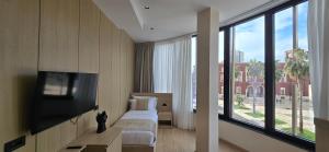 a hotel room with a bed and a flat screen tv at Koral Boutique Hotel in Durrës