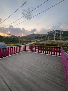 a balcony with a red fence and a road at Siriwan boutique hotel in Ban Met Nang Chi