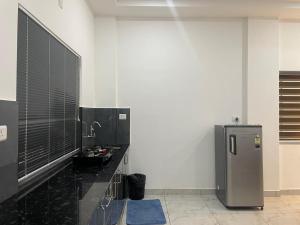 a kitchen with a black counter and a refrigerator at Dream Castle in Cochin +4 photos