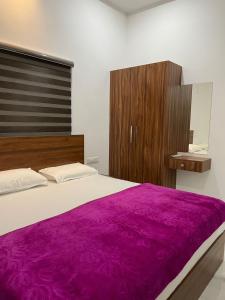 a bedroom with a large bed with a purple blanket at Dream Castle in Cochin