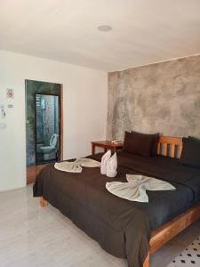 a bedroom with a large bed with towels on it at Lung peiyk homestay in Ban Bang Bao