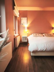 a bedroom with a white bed and a red wall at B&B Lisdodde in Lissewege