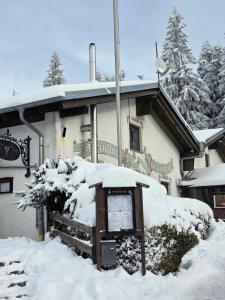a snow covered building with a sign in front of it at Waldfeder Apartment mit Pool und Fitnessraum, neu und vollsaniert in Sankt Englmar