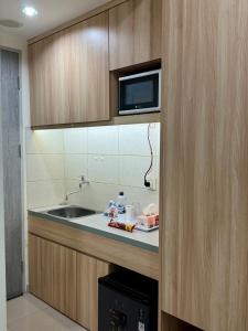 a kitchen with a sink and a microwave at Osaka Riverview Apartment PIK 2 in Rawalumpang