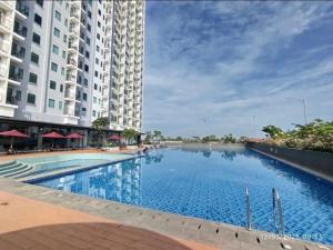 a large swimming pool in front of a building at Osaka Riverview Apartment PIK 2 in Rawalumpang