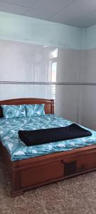 a bedroom with a bed with a wooden frame at LUNA House in Phú Vang