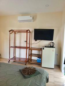 a living room with a television and a refrigerator at Lung peiyk homestay in Ban Bang Bao