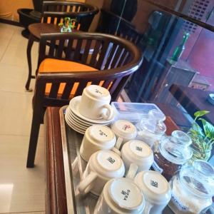 a table with cups and plates on top of it at Hotel Rumah Shinta in Jakarta