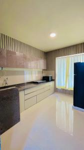 a large kitchen with white cabinets and a sink at Shubh causy 4bhk villa in Lonavala +2 photos