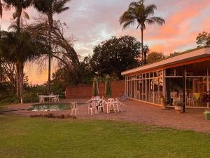 a patio with tables and chairs next to a building at Mon Desir Estate - BR4 in Pietermaritzburg