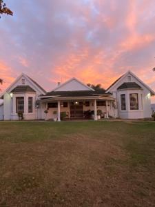 two white houses with a sunset in the background at Mon Desir Estate - BR4 in Pietermaritzburg