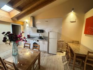 a kitchen and dining room with a table and a refrigerator at Apartamentos San Nicolás AIRE AC y ascensor junto a Laurel in Logroño