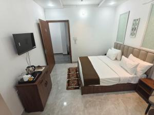 a bedroom with a bed with a tv at Hotel Yashoday in Kekri
