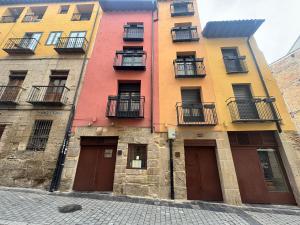 a row of colorful buildings on a street at Apartamentos San Nicolás AIRE AC y ascensor junto a Laurel in Logroño