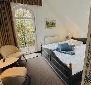 a bedroom with a bed and a large window at Am Wasserturm Pension in Bad Muskau