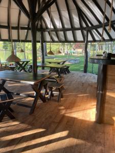 a group of picnic tables in a tent at Aji fruit farm cottage peaceful lakeside farm stay with sunrise views 01 in Embilipitiya