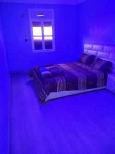 a bedroom with a bed in a purple room at شقق الخيالي 1 in Tan-Tan