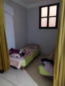 a small room with two beds and a window at شقق الخيالي 1 in Tan-Tan
