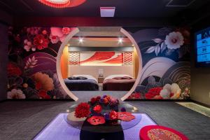 a room with two beds and a table with flowers at HOTEL ARIA-Yokohama Kannai in Yokohama