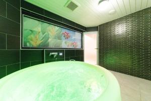 a bath tub in a bathroom with a painting on the wall at HOTEL ARIA-Yokohama Kannai in Yokohama +53 photos