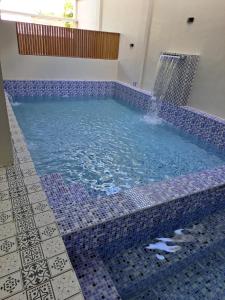 a blue tiled swimming pool with a water fountain at Maywood Private Resort in Calamba
