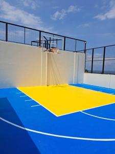 an indoor basketball court with blue and yellow at Maywood Private Resort in Calamba