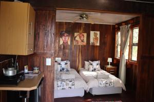 a bedroom with two beds in a wooden wall at Mukuku Oasis Lodge in Shimweghe +77 photos